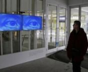Interactive video installation, 2012, Dimension variable, silent.nnInteractive video installation using a computer, software large monitors and a Kinect sensor: Two large monitors display an eye. As the viewer walks past the monitor, the eyes follow their motion. The screens “watch” the viewer, and track their motions. In an adjacent area, a video loop plays of an extreme close up of an eye that blinks in slow motion. This aspect of the installation emphasizes the human element of surveillan