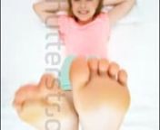 Happy Girl doing exercise on bed with bare feet in the air from feet girl